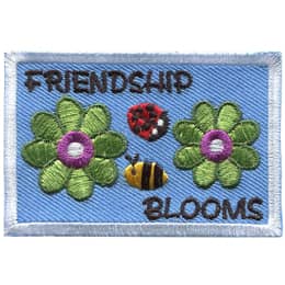 The words Friendship Blooms are surrounding a bee and ladybug, and two green flowers.