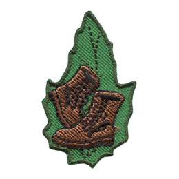 A pair of brown boots on a green leaf.