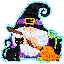 A gnome dressed as a witch with a black cat and broomstick.