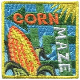 The words corn maze next to some corn.